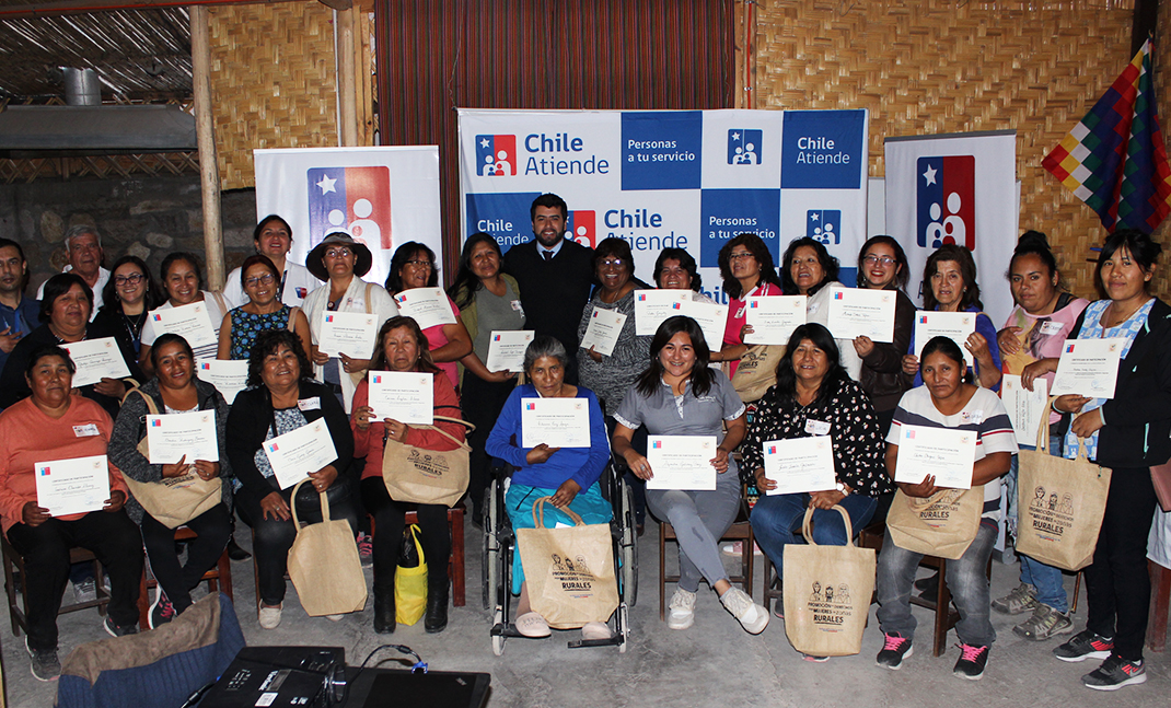 Grupo de mujeres participantes de talleres con diplomas en sus manos.