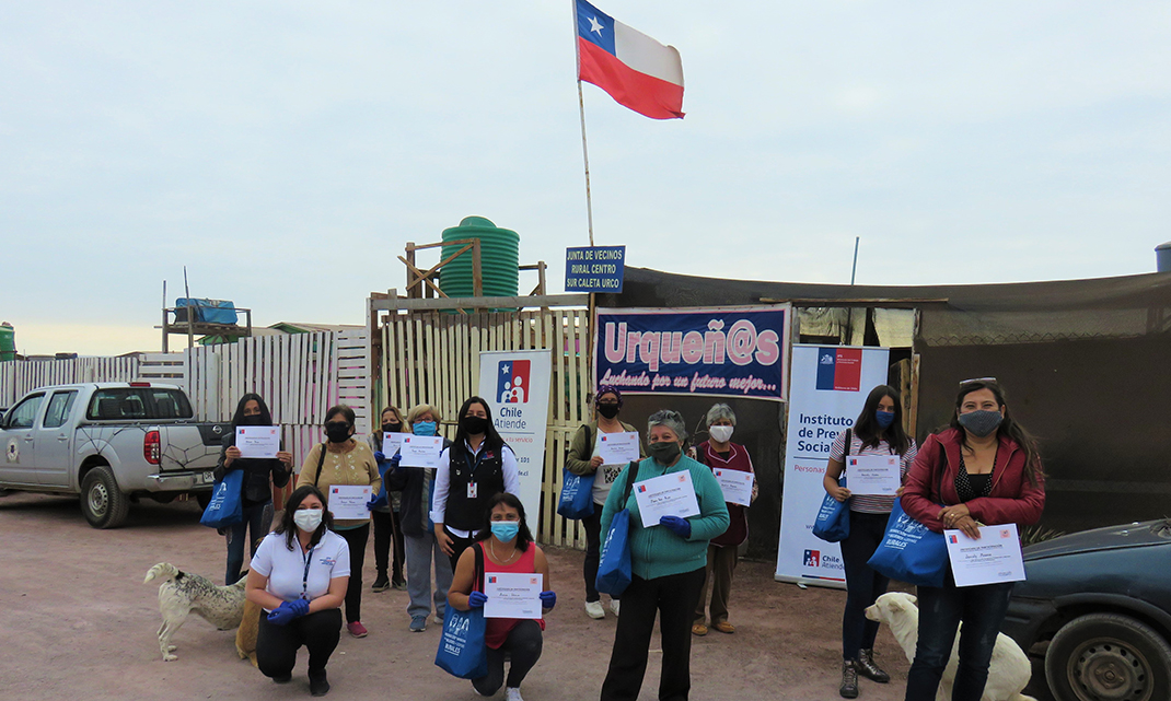 Mujeres participantes de talleres exhibiendo sus diplomas.