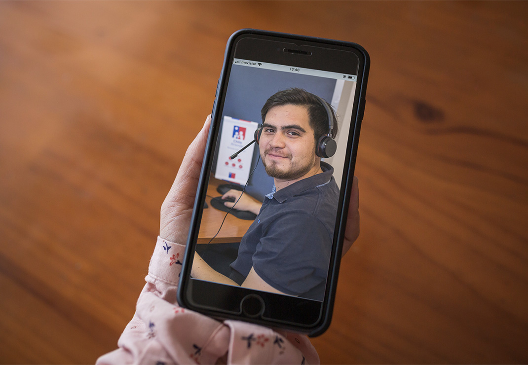 Mano de persona sosteniendo un celular con imagen de funcionario IPS.