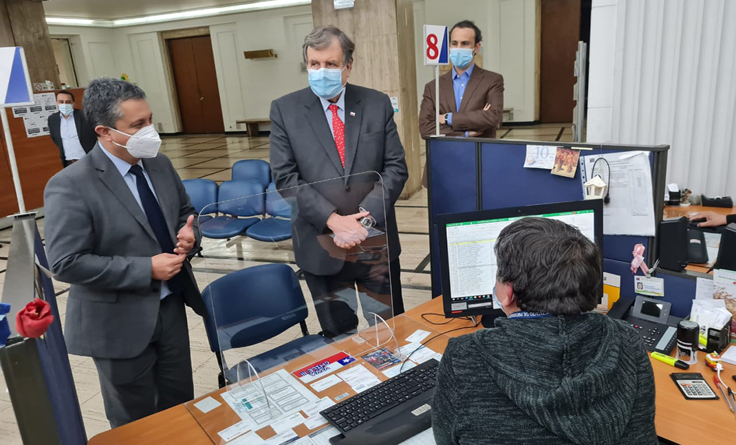 El ministro del Trabajo y el director del IPS conversando con funcionarios.