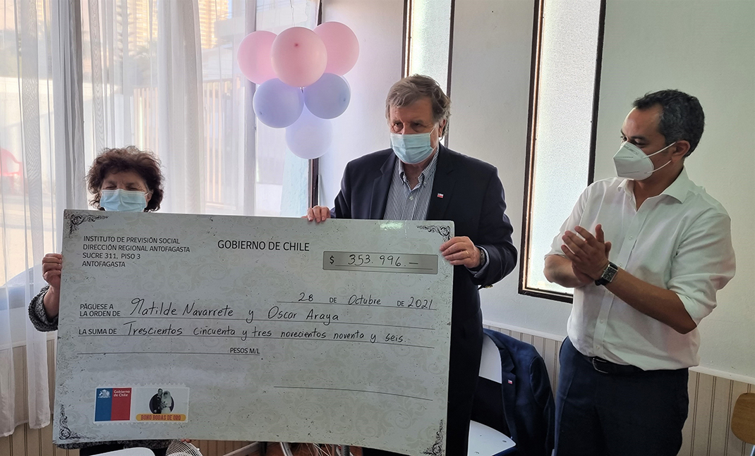 Ministro del Trabajo entrega cheque gigante simbólico a beneficiaria del Bono Bodas de Oro.